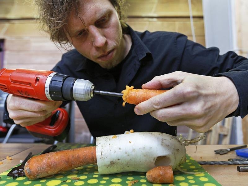 El músico austríaco Matthias Meinharter, quien es miembro de esta orquesta, utiliza un taladro de mano para hacer uno de los instrumentos a utilizar.