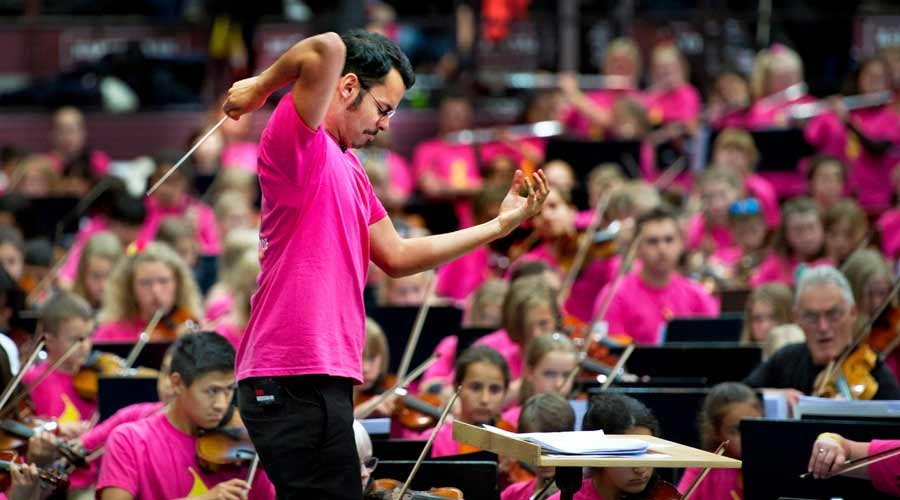 Ron Álvarez dirigiendo a más de 500 jóvenes en el Festival Side By Side. El director de 30 años creó en junio la Orquesta de Sueños de El Sistema Suecia. Credit Cortesía de Lisa Thanner/El Sistema Suecia